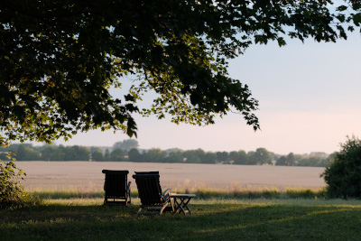 Landschaftsbild mit Gartenstühlen vor Wiese vom Gutshaus Zarchlin 